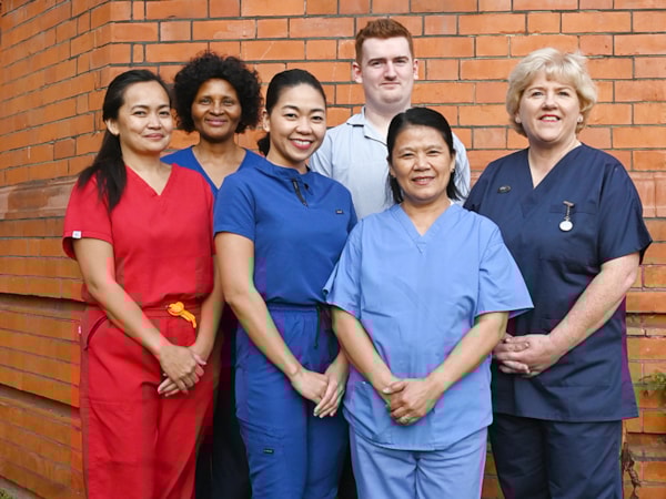 Group of ED nurses outside Richmond Building smiling at camera